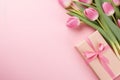 Beautiful pink tulips flowers and present. Romantic gift wallpaper with space for text. Light gentle pink color bouquet