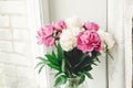 Beautiful pink and white peonies bouquet at rustic old wooden window. Floral decor and arrangement. Gathering flowers. Rural still