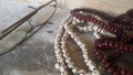 Beautiful plastic prayer beads or rosary placed over concrete background