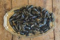 Beautiful plate of metal with heap of cooked mussels on old non paitn wooden background Royalty Free Stock Photo