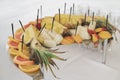 A beautiful platter of fruits and berries. Canapes on skewers look very colorful and appetizing