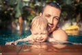 Beautiful playful child baby kid smiling parent father together fun swimming pool splashes Royalty Free Stock Photo