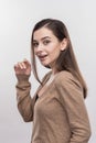 Beautiful pleasant young woman standing in front of white wall