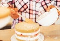 Beautiful pleased pastry chef woman making cake with cream at cozy kitchen Royalty Free Stock Photo