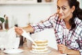 Beautiful pleased pastry chef woman making cake with cream at cozy kitchen Royalty Free Stock Photo