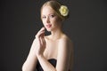 Plus size blonde with a yellow rose in her hair posing on a gray seamless background Royalty Free Stock Photo