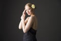 Plus size blonde with a yellow rose in her hair posing on a gray seamless background Royalty Free Stock Photo