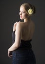 Plus size blonde with a yellow rose in her hair posing on a gray seamless background Royalty Free Stock Photo