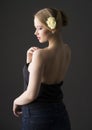 Plus size blonde with a yellow rose in her hair posing on a gray seamless background Royalty Free Stock Photo