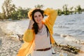 Beautiful plus size woman in yellow jacket on sandy shore