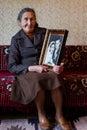 Beautiful 80 plus year old senior woman holding her wedding photograph. Love forever concept