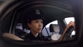 Beautiful police woman driving car, monitoring traffic law and order in city Royalty Free Stock Photo