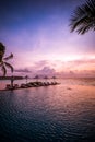 Umbrellas and chairs, infinity swimming pool with sunset sea sky view. Luxury holiday resort vacation travel concept Royalty Free Stock Photo