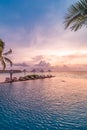 Umbrellas and chairs, infinity swimming pool with sunset sea sky view. Luxury holiday resort vacation travel concept Royalty Free Stock Photo