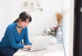 Beautiful portrait asia young woman working online on laptop sitting at cafe shop, professional female freelance using notebook Royalty Free Stock Photo