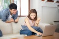 Beautiful portrait asian young couple working laptop with smile and happy sitting on couch at living room Royalty Free Stock Photo