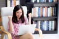 Beautiful of portrait asian young woman excited and glad of success with laptop on chair, girl working living room Royalty Free Stock Photo