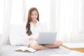 Beautiful of portrait asian young woman setting on bed using laptop computer and notebook at bedroom for leisure and relax Royalty Free Stock Photo