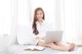 Beautiful of portrait asian young woman setting on bed using laptop computer and notebook at bedroom for leisure and relax Royalty Free Stock Photo