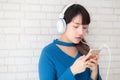 Beautiful portrait asian young woman standing happy enjoy and fun listen music with headphone on cement concrete background Royalty Free Stock Photo