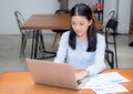 Beautiful of portrait asian young woman working with graph statistic paper on laptop sitting at coffee shop Royalty Free Stock Photo