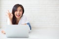 Beautiful portrait asian young woman working online laptop with excited lying on floor brick cement background, freelance girl Royalty Free Stock Photo