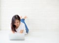 Beautiful of portrait asian young woman working online laptop lying on floor brick cement background, freelance girl using Royalty Free Stock Photo