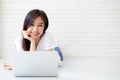 Beautiful of portrait asian young woman working online laptop lying on floor brick cement background Royalty Free Stock Photo