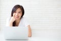 Beautiful of portrait asian young woman working online laptop lying on floor brick cement background Royalty Free Stock Photo