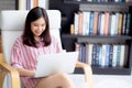 Beautiful of portrait asian young woman working online laptop sitting on chair at living room Royalty Free Stock Photo