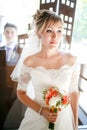 Beautiful portrait of bride with groom behind glass, wedding bouquet in hands indoors. Royalty Free Stock Photo