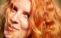 Beautiful portrait in closeup of a smiling young red-haired curly woman Royalty Free Stock Photo