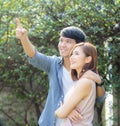 Beautiful portrait couple looking each others eyes and smiling with happy, young asian man and woman relation pointing something Royalty Free Stock Photo