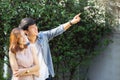 Beautiful portrait couple looking each others eyes and smiling with happy, young asian man and woman relation pointing something Royalty Free Stock Photo