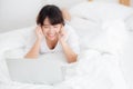 Beautiful portrait freelance asian young woman lying relax and leisure working laptop computer internet online on bed