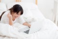 Beautiful portrait freelance asian young woman lying relax and leisure working laptop computer internet online on bed