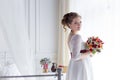 Beautiful portrait of a gentle cute happy bride in a white dress with a bright little colored bouquet Royalty Free Stock Photo