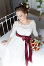 Beautiful portrait of a gentle cute happy bride in a white dress with a bright little colored bouquet