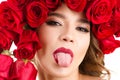 Beautiful portrait girl with roses on head and out tongue Royalty Free Stock Photo