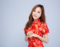 Beautiful portrait happy Chinese New Year young asian woman wear cheongsam fashion smile with gesture congratulation Royalty Free Stock Photo