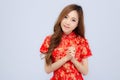 Beautiful portrait happy Chinese New Year young asian woman wear cheongsam smile with gesture congratulation and greeting Royalty Free Stock Photo