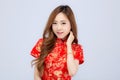 Beautiful portrait happy Chinese New Year young asian woman wear cheongsam smile with gesture congratulation and greeting isolated Royalty Free Stock Photo