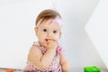 Beautiful portrait of little baby girl sucking finger in red clothes Royalty Free Stock Photo