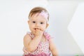 Beautiful portrait of little baby girl sucking finger in red clothes Royalty Free Stock Photo