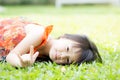 Beautiful portrait little girl asian of a smiling lying on green grass at the park Royalty Free Stock Photo