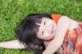 Beautiful portrait little girl asian of a smiling lying on green grass at the park Royalty Free Stock Photo