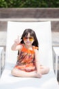 Beautiful portrait little girl asian of a smiling sitting at swimming pool Royalty Free Stock Photo