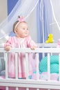 Beautiful portrait of a little girl in a pink dress in a nursery Royalty Free Stock Photo