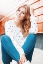 Beautiful portrait of a pretty smiling girl near stylish orange