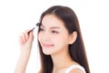 Beautiful portrait young asian woman applying eyebrow or eyelash with makeup brush isolated on white background Royalty Free Stock Photo